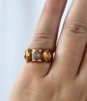 la main d'une femme tenant une bague sertie d'un diamant
