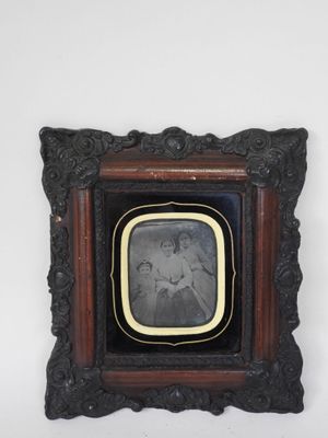 an old photo of a woman in a black dress in a wooden frame