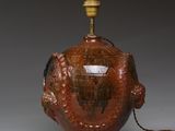 une image représentant un vase marron surmonté d'une lampe
