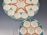 deux assiettes ornées d'étoiles de mer, posées sur un présentoir