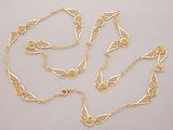 a close up of a gold chain with a knot on it