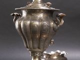 a silver plate with a silver vase and a silver cup on it