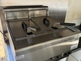 une photo d'un plan de travail en acier inoxydable sur lequel est posée une friteuse
