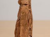 wooden figurine of a woman holding a child on a table