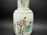 un vase avec un tableau posé sur une table