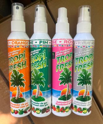 three spray bottles of tropical fresh are lined up on a table