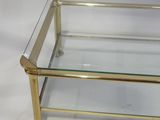 a brass and glass coffee table with a glass top