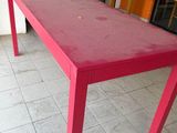 a red table that is sitting on a tiled floor