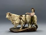 a figurine of a man on a horse and a cow