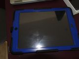 une tablette bleue posée sur une table à côté d'un ordinateur portable