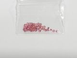 a small bag filled with pink crystals sitting on top of a white surface