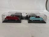 two toy cars are sitting in a display case on a white surface