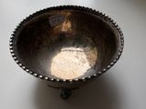 a silver bowl sitting on a table with a tag on it