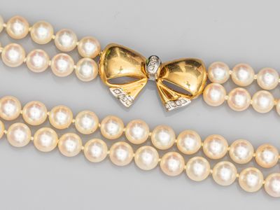 un gros plan sur un collier orné de perles et d'un nœud