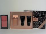 two bottles of perfume in a pink box with a black and white box