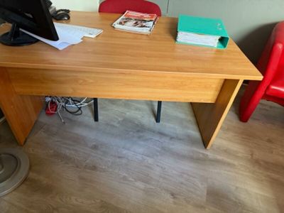a wooden desk with a computer monitor and a red chair