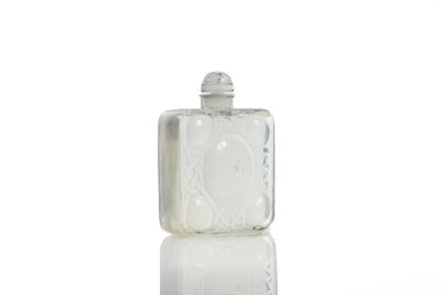 a small glass bottle with a lid on a white surface