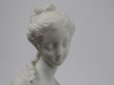 a white statue of a woman with a flower in her hair