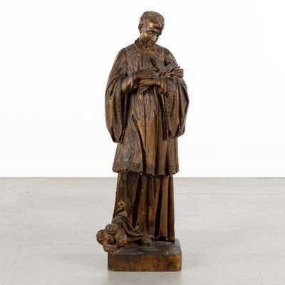 a wooden statue of a man holding a dog in his arms