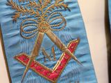 a man wearing a blue tie with a masonic emblem on it