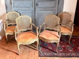 four chairs are sitting in a room with a rug on the floor