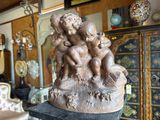 a statue of three children on a pedestal in a room