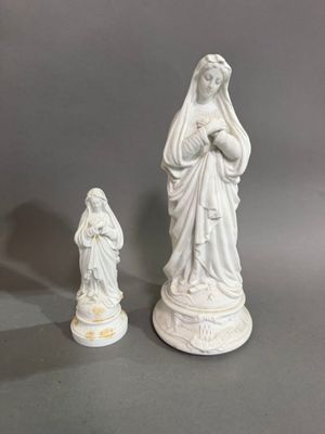 deux statues blanches représentant Jésus et Marie sur un fond gris