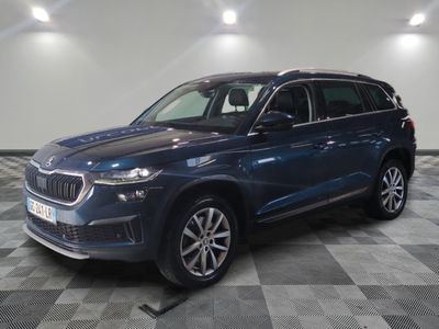 un SUV BMW bleu garé sur un sol à damier dans un garage