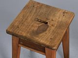 a small wooden stool with a hole in it
