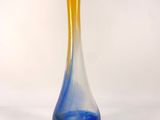 a blue and yellow vase sitting on a white surface