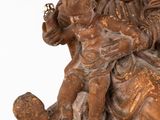 an old statue of a woman holding a baby and a child