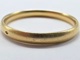 gros plan d'une bague en or sur une surface blanche