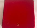 une boîte rouge posée sur une table blanche