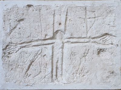 relief of a cross carved into a stone wall in a church