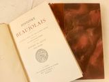 un livre ouvert posé sur une table à côté d'un livre ouvert