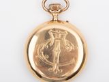 an antique gold pocket watch with a cross on the front
