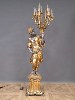 an image of a statue of a man holding a candelabra on a wooden floor