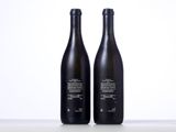 two bottles of wine sitting next to each other on a table