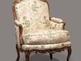 une chaise ancienne dont l'assise est recouverte d'un tissu à motifs floraux