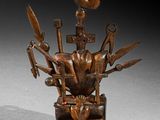 statue of a man with a bird on top of his head surrounded by tools