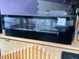 un comptoir muni d'une vitrine en verre et d'une pancarte