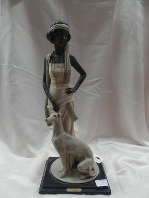 statue d'une femme accompagnée d'un chien, posée sur un socle, sur fond blanc