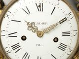 a gold clock with a face of a woman on it