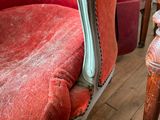 a red chair that is sitting on a wooden floor