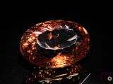 an orange and black diamond sitting on top of a black surface