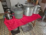 pots and pans on a table in a kitchen with a red table cloth