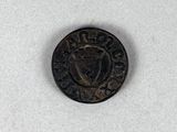 une vieille pièce de monnaie sur laquelle figure une couronne, posée sur une surface blanche