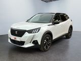 Le SUV blanc est garé dans une grande pièce équipée d'un ventilateur de plafond.