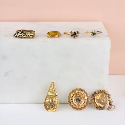 several gold rings and rings are sitting on a marble block