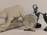 une statue d'ours polaire à côté d'une horloge et d'une statue de femme